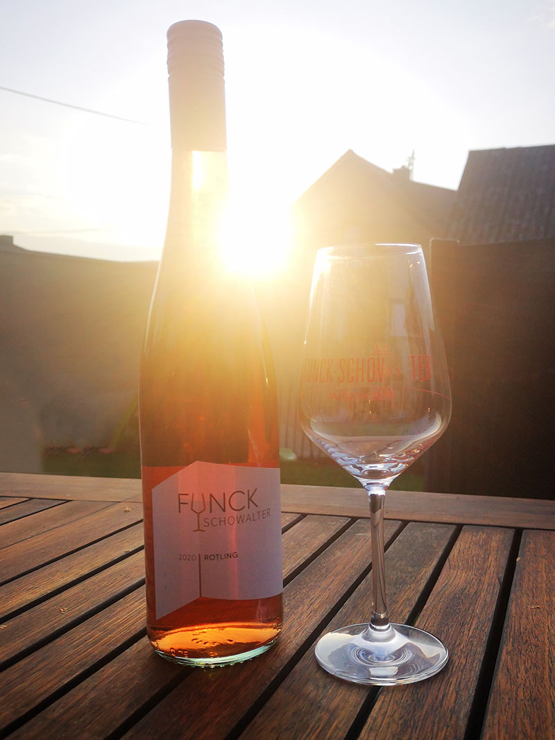 Weinflasche mit Glas vor Sonnenuntergang